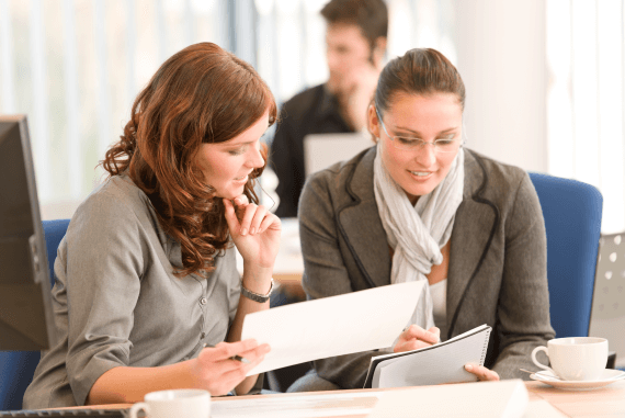 Two female colleagues working together as a team Two female colleagues working together as a team