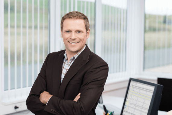A male manager smiling with arms folded A male manager smiling with arms folded