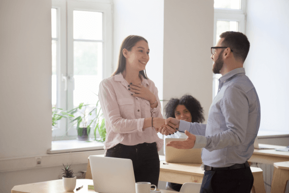 A female employee being told about a promotion at work A female employee being told about a promotion at work
