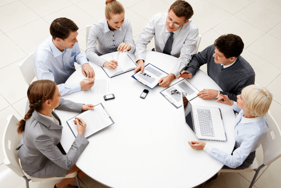 A business team having a meeting sat at a round table A business team having a meeting sat at a round table