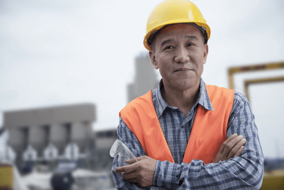 A construction health and safety worker with arms folded