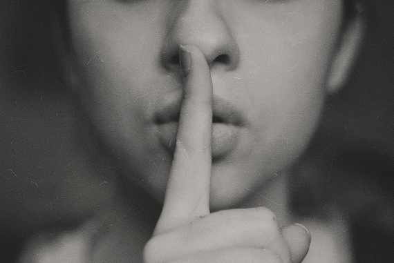 Fingers to lips representing quiet