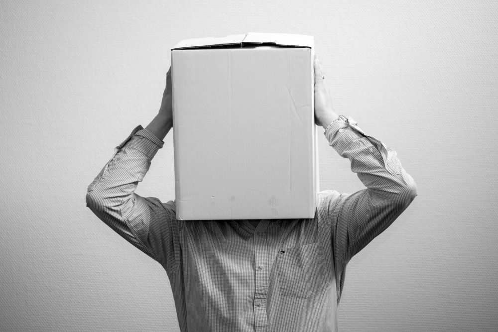 A manager hiding with a box over their head