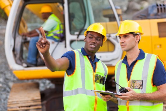 A construction worker and site manager in discussion about risks on site