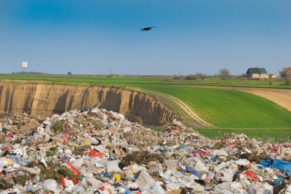 Landfill rubbish site with green countryside behind