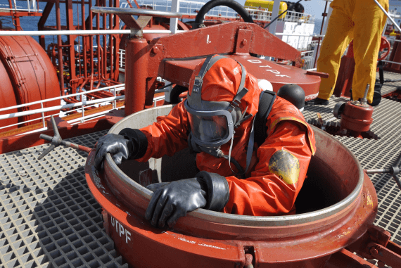 An oil and gas worker emerging from a confined space