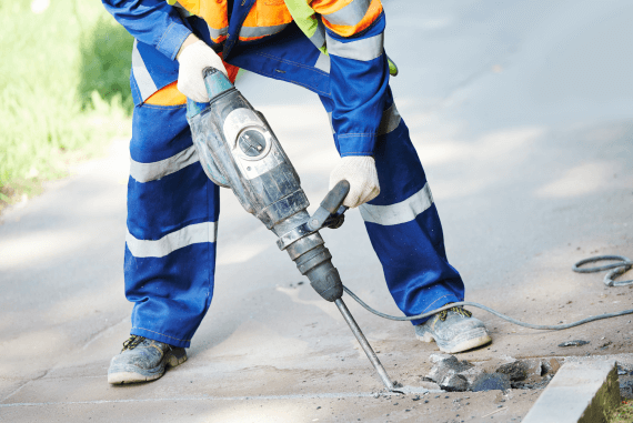 A road worker using a pneumatic drill piece of equipment