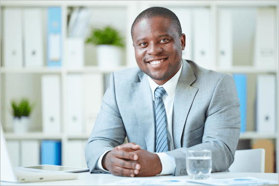 A smiling corporate executive sat at a desk