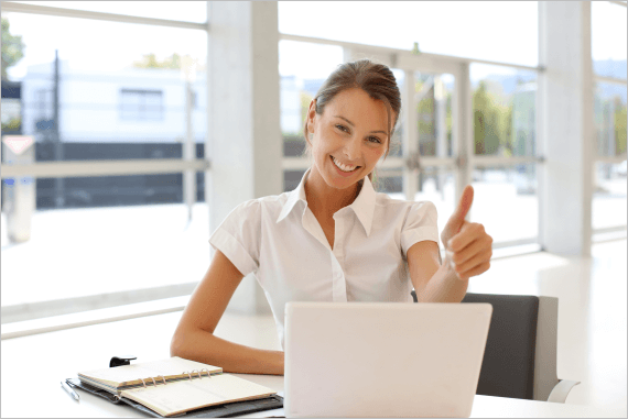 Worker thumbs up sat at laptop computer